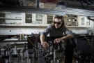 Photograph of Jean-Philippe MacLean at work on his experiment at the University of Waterloo