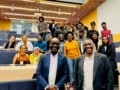 A photo of Mark Richards and Washington Ochieng, together with a large group of Black physicists, in a lecture theatre