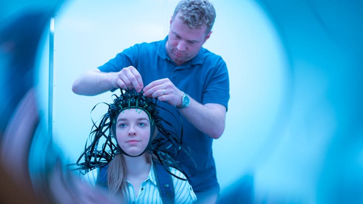 A test patient is fitted with a MEG scanner helmet