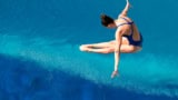 Woman diving into clear blue water