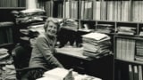 Gertrude Goldhaber sitting at her desk