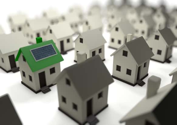 Conceptual image of one green house among lots of grey houses