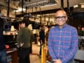 A photo of Venkatraman Gopalan in his optical lab, wearing laser safety goggles and smiling broadly. Other people in the background work at a laboratory bench.