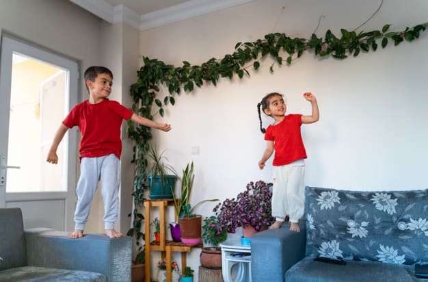 two young children playing on sofas