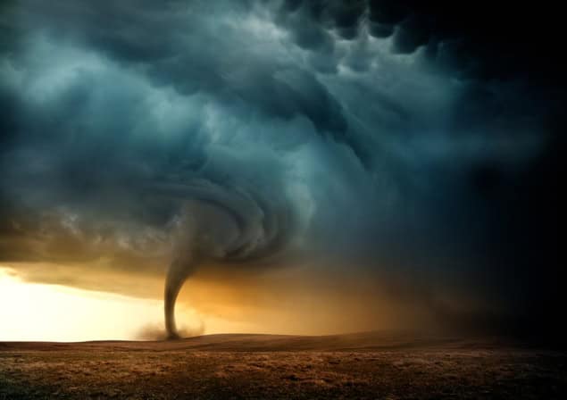 Image of a tornado and dark clouds against a bright horizon