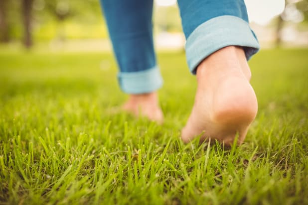 person walking barefoot on grass