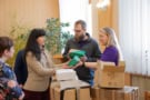 Four people unpacking cardboard boxes